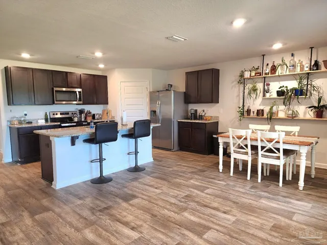 a kitchen with stainless steel appliances kitchen island granite countertop a sink and cabinets
