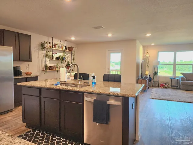 a kitchen with kitchen island granite countertop a sink and cabinets