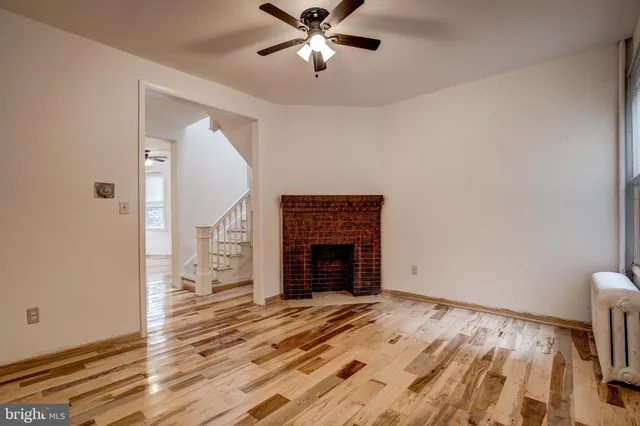 an empty room with fireplace and wooden floor