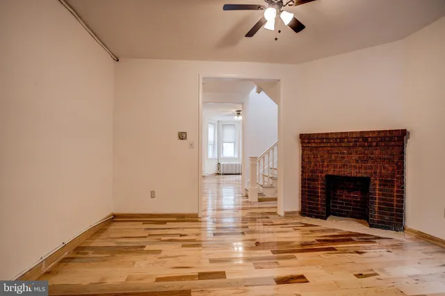a view of empty room with fireplace and fan