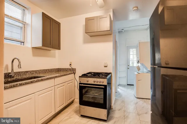 a kitchen with a stove top oven and refrigerator