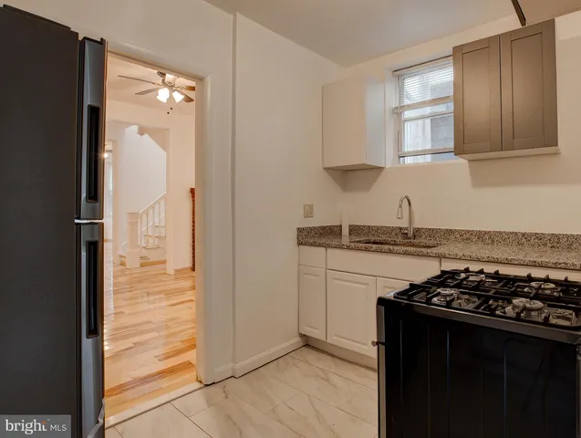 a kitchen with granite countertop a stove and a refrigerator
