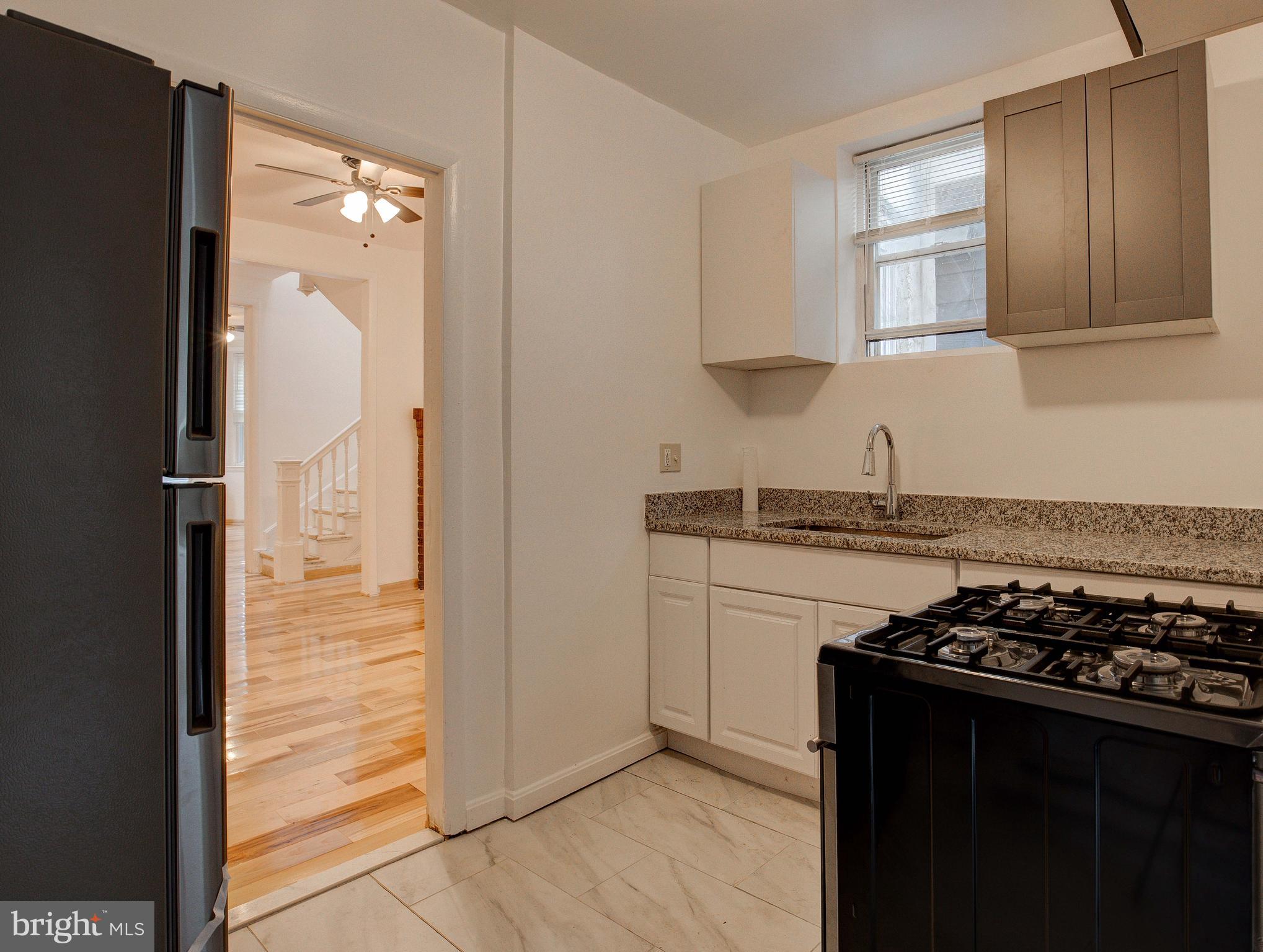 1528 E Street Southeast Washington, DC 20003 - Photo 15 of 30 a kitchen with granite countertop a stove and a refrigerator