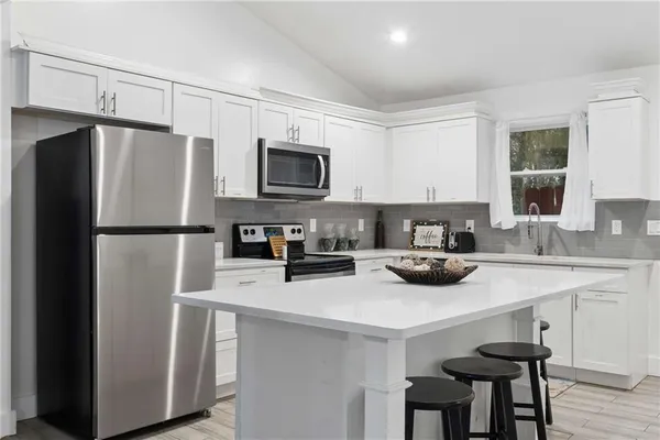 a kitchen with stainless steel appliances a refrigerator stove microwave and sink
