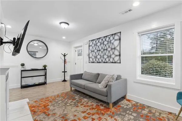 a living room with furniture a rug and a flat screen tv