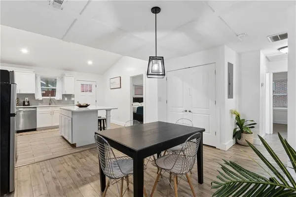 a kitchen with a table chairs refrigerator and microwave