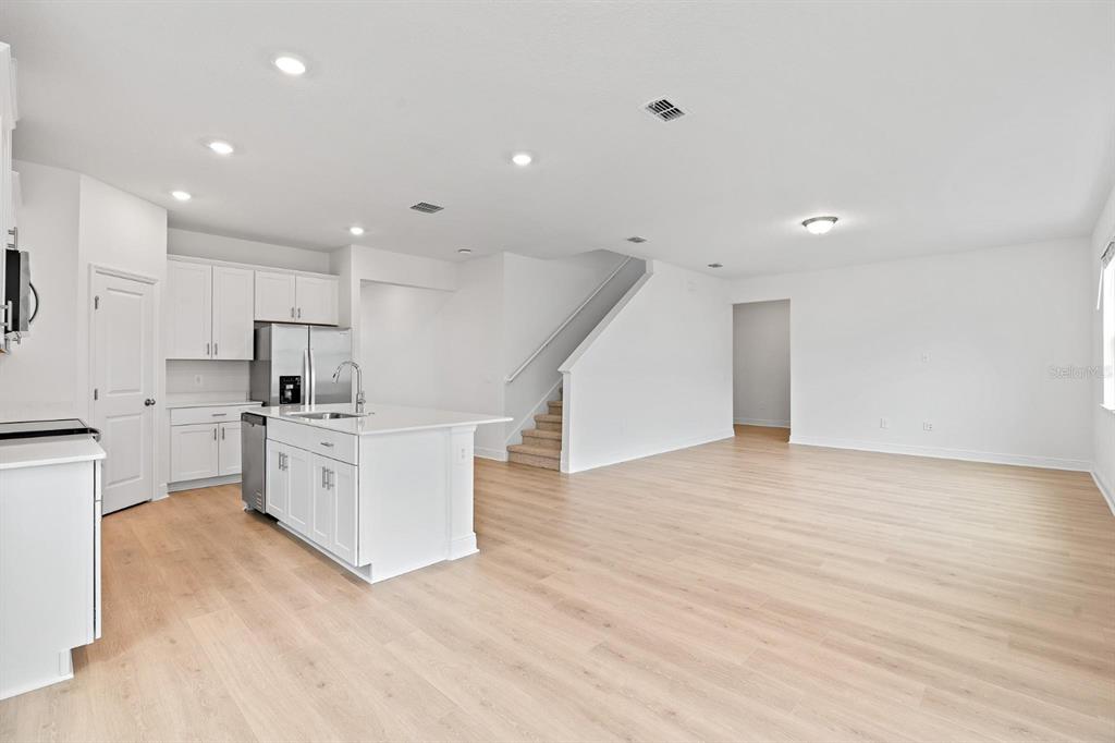 2276 Hen Road Minneola, FL 34715 - Photo 14 of 40 a kitchen with white cabinets and stainless steel appliances