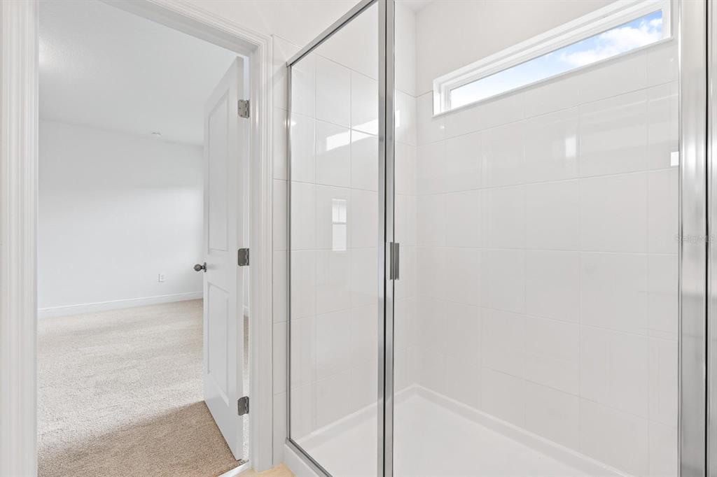 2276 Hen Road Minneola, FL 34715 - Photo 30 of 40 a bathroom with a glass shower door