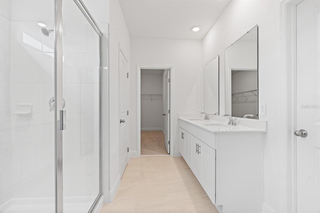 2276 Hen Road Minneola, FL 34715 - Photo 31 of 40 a bathroom with a double vanity sink and mirror