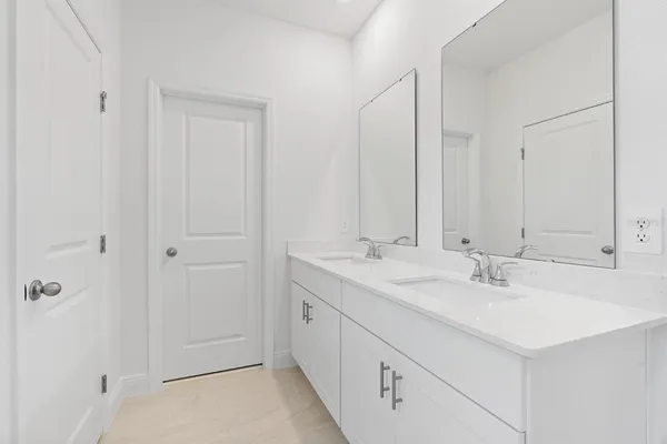 a bathroom with 2 sink and a mirror