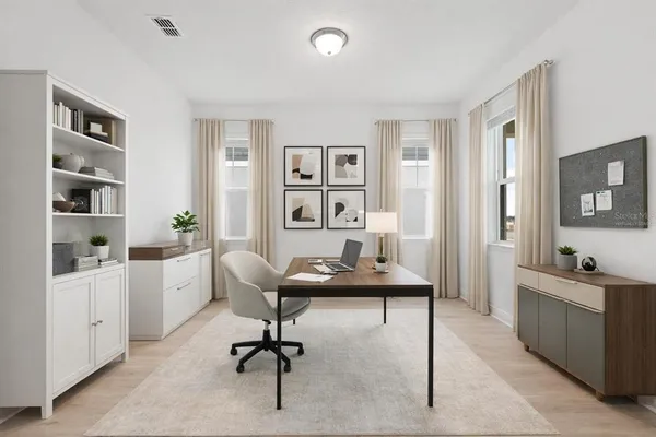 a view of a workspace with furniture and wooden floor