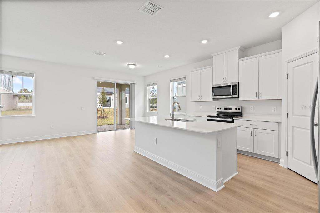 2276 Hen Road Minneola, FL 34715 - Photo 6 of 40 a kitchen with stainless steel appliances a refrigerator sink and microwave