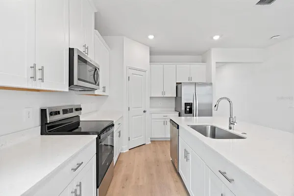 a kitchen with white cabinets and white appliances