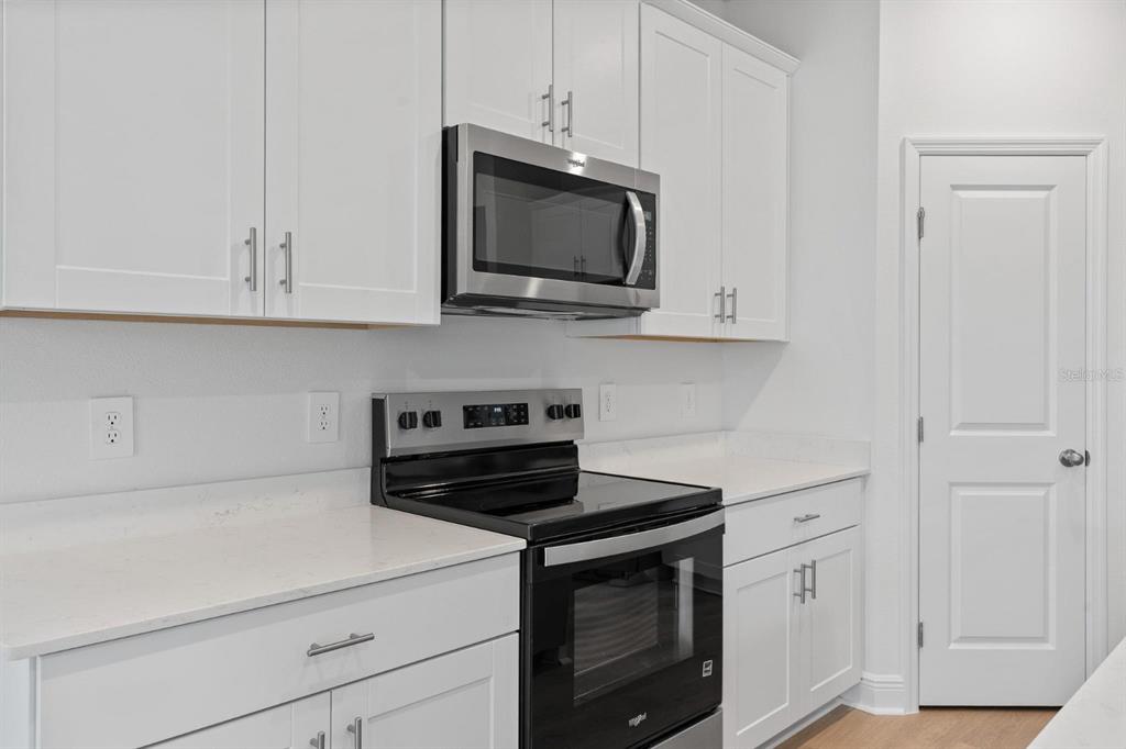 2276 Hen Road Minneola, FL 34715 - Photo 9 of 40 a kitchen with stainless steel appliances granite countertop white cabinets and a stove a oven with white countertops