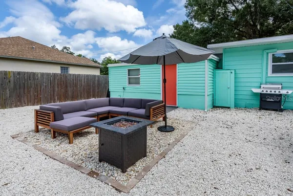 a view of a backyard with furniture and a fire pit