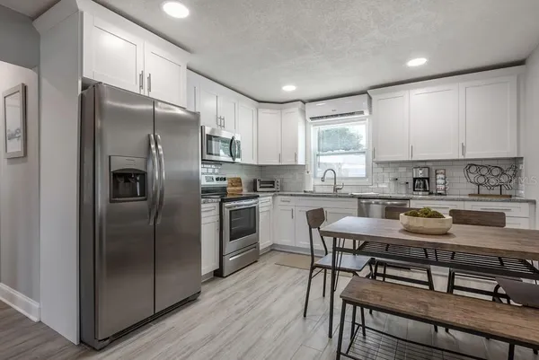 a kitchen with a refrigerator a stove a sink and cabinets