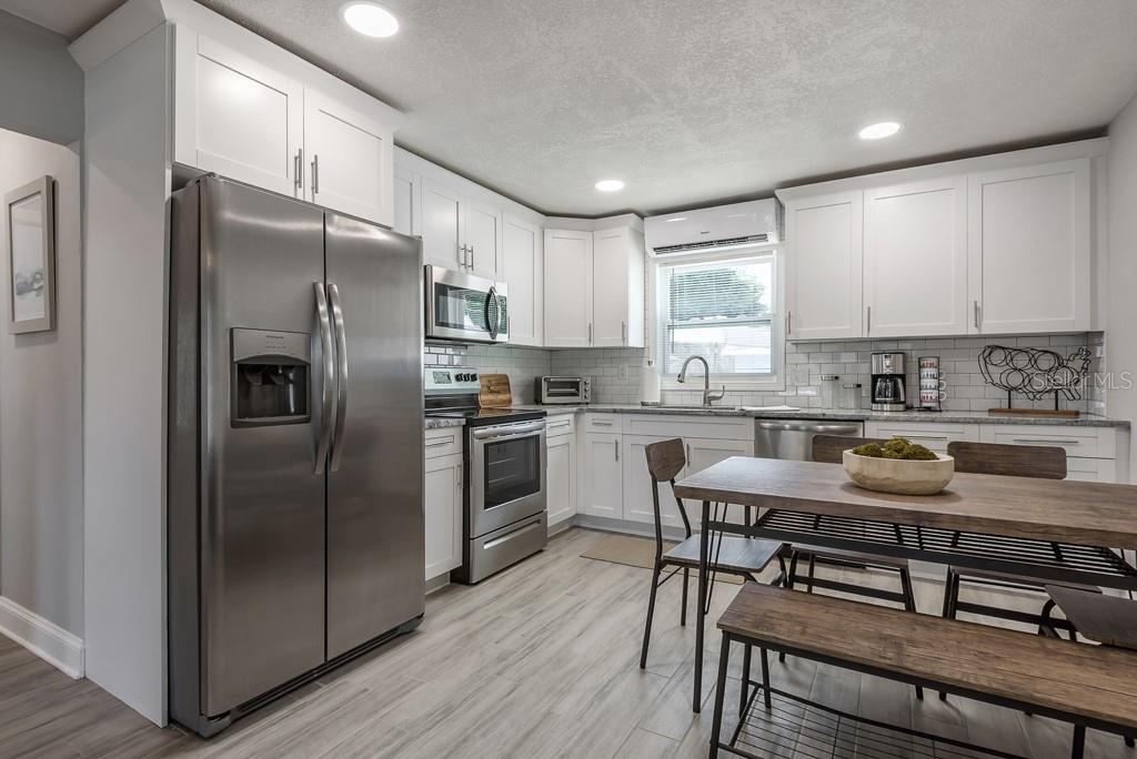15732 Bolesta Road, Unit A Clearwater, FL 33760 - Photo 4 of 13 a kitchen with a refrigerator a stove a sink and cabinets