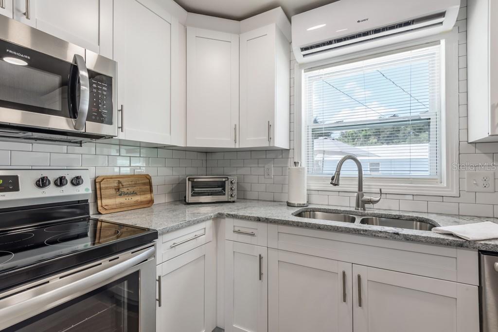 15732 Bolesta Road, Unit A Clearwater, FL 33760 - Photo 6 of 13 a kitchen with stainless steel appliances white cabinets a sink and a stove