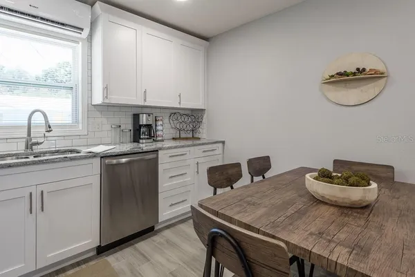 a kitchen with a table chairs sink and cabinets