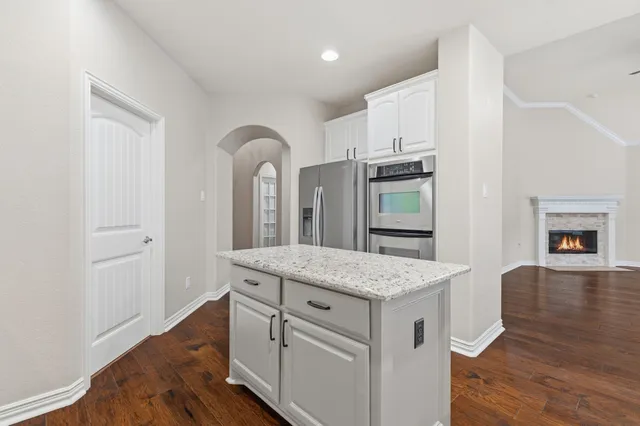 a kitchen with cabinets and wooden floor