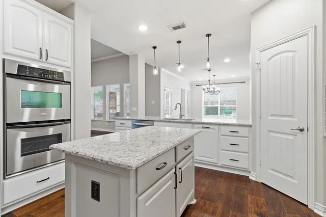 a kitchen with white cabinets and appliances