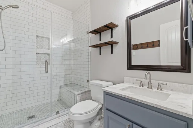 a bathroom with a granite countertop sink toilet and shower