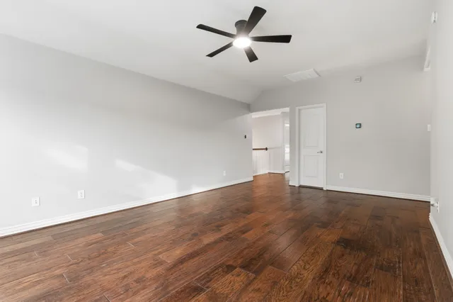 an empty room with a window and a ceiling fan