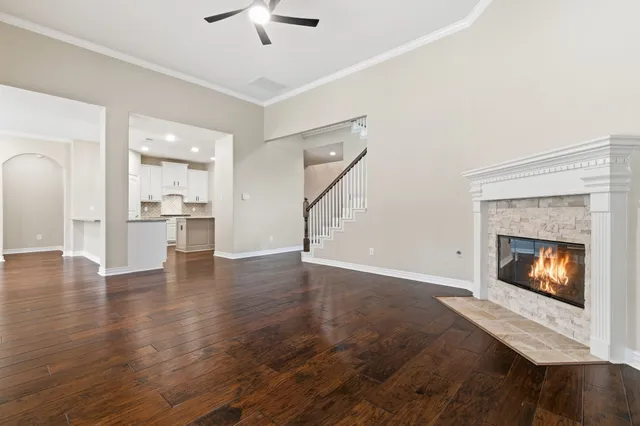 an empty room with wooden floor a fireplace and windows