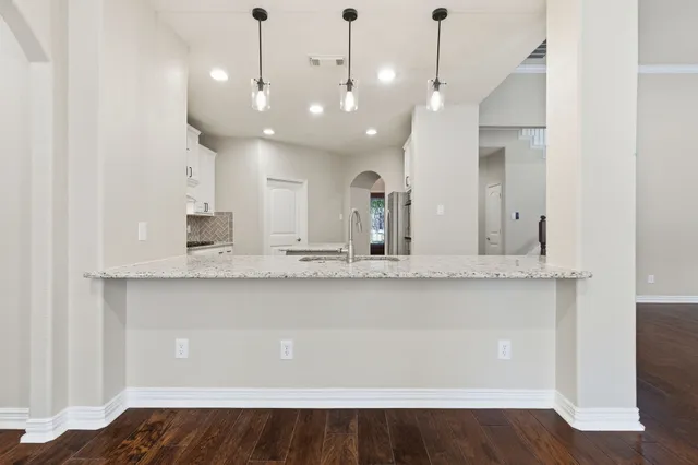 a view of a kitchen with a sink and dishwasher a refrigerator with wooden floor