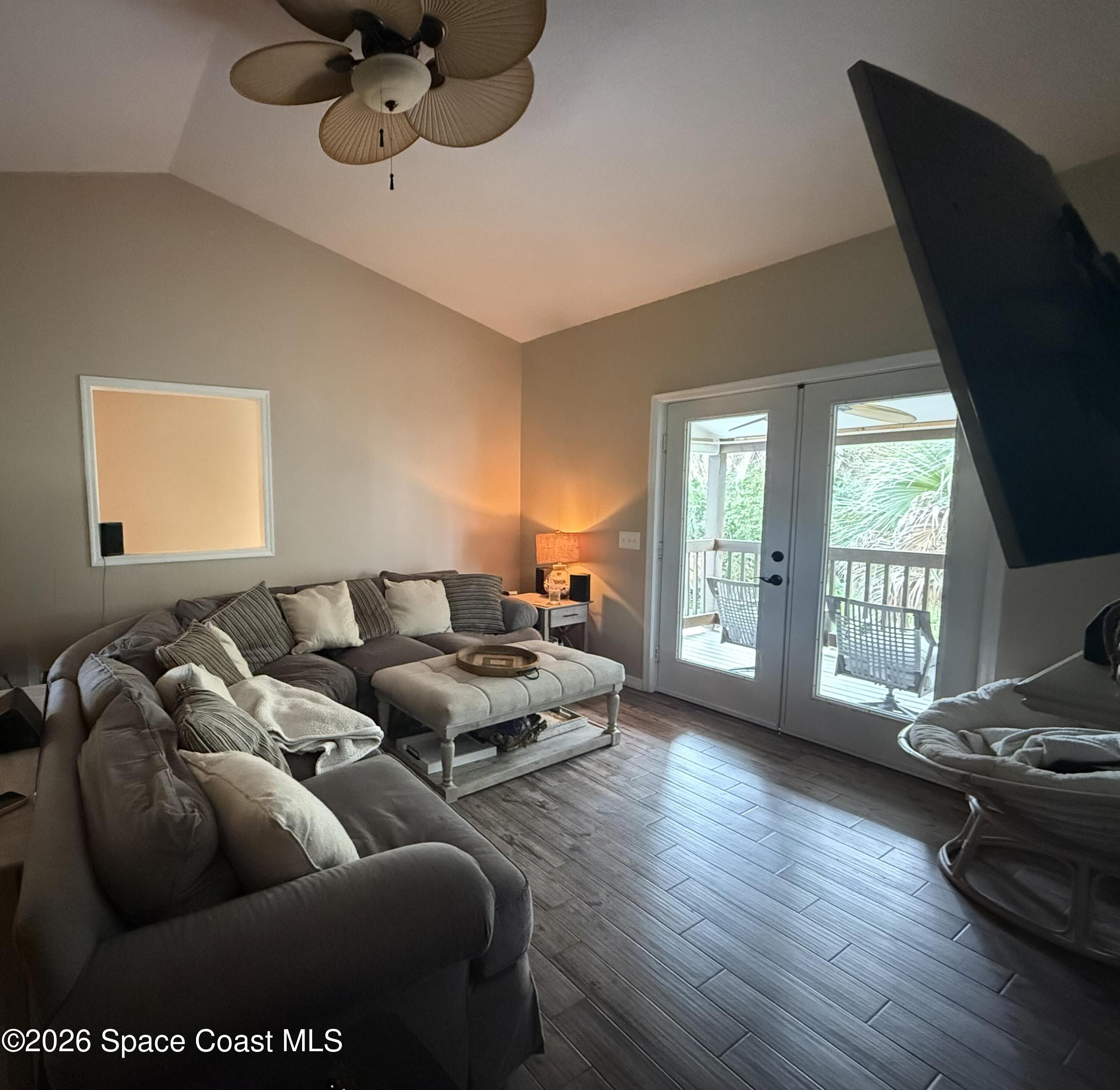 111 Seagrape Road Melbourne Beach, FL 32951 - Photo 16 of 19 a living room with furniture wooden floor and a large window