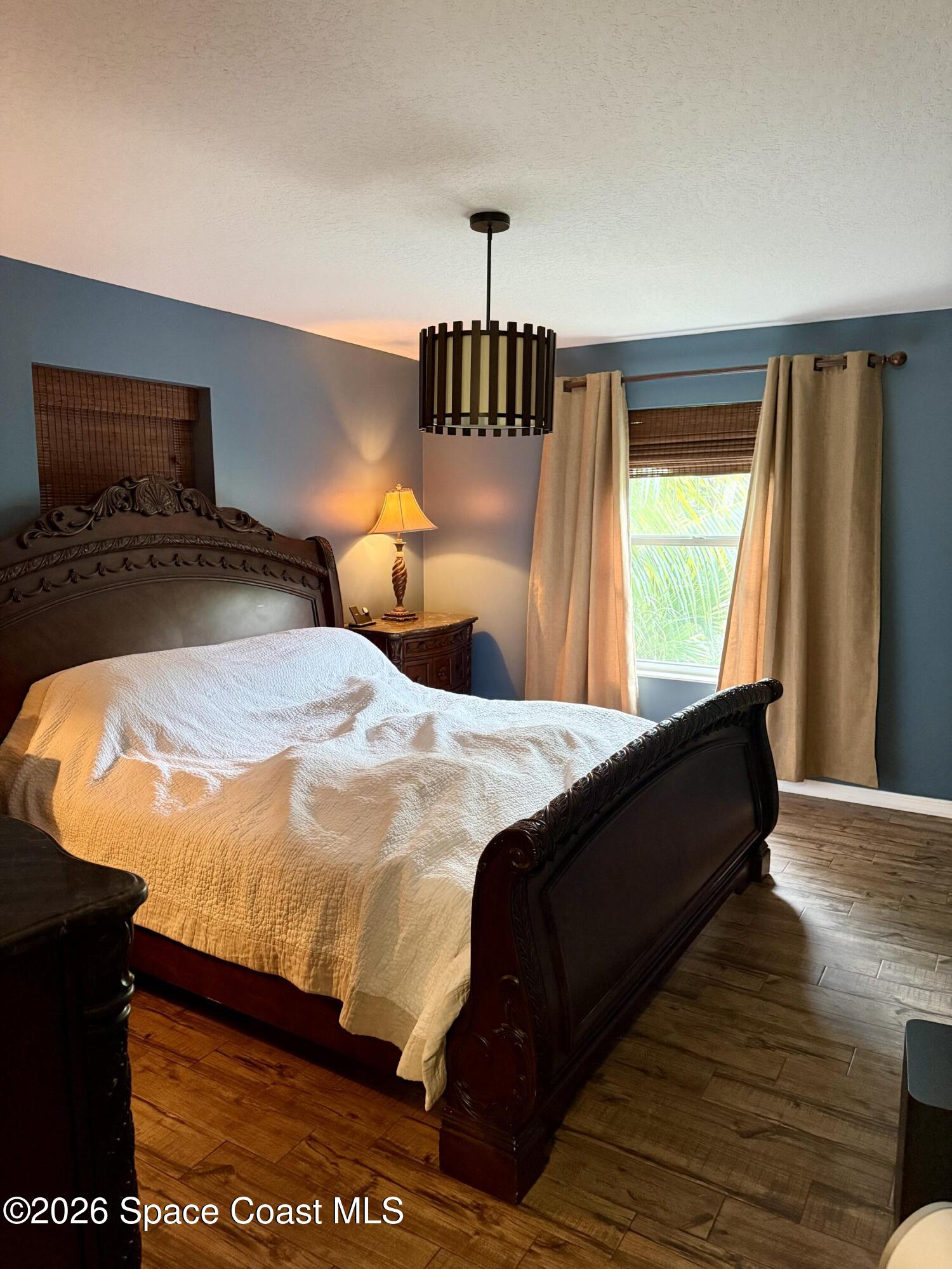 111 Seagrape Road Melbourne Beach, FL 32951 - Photo 17 of 19 a bedroom with a bed and wooden floor