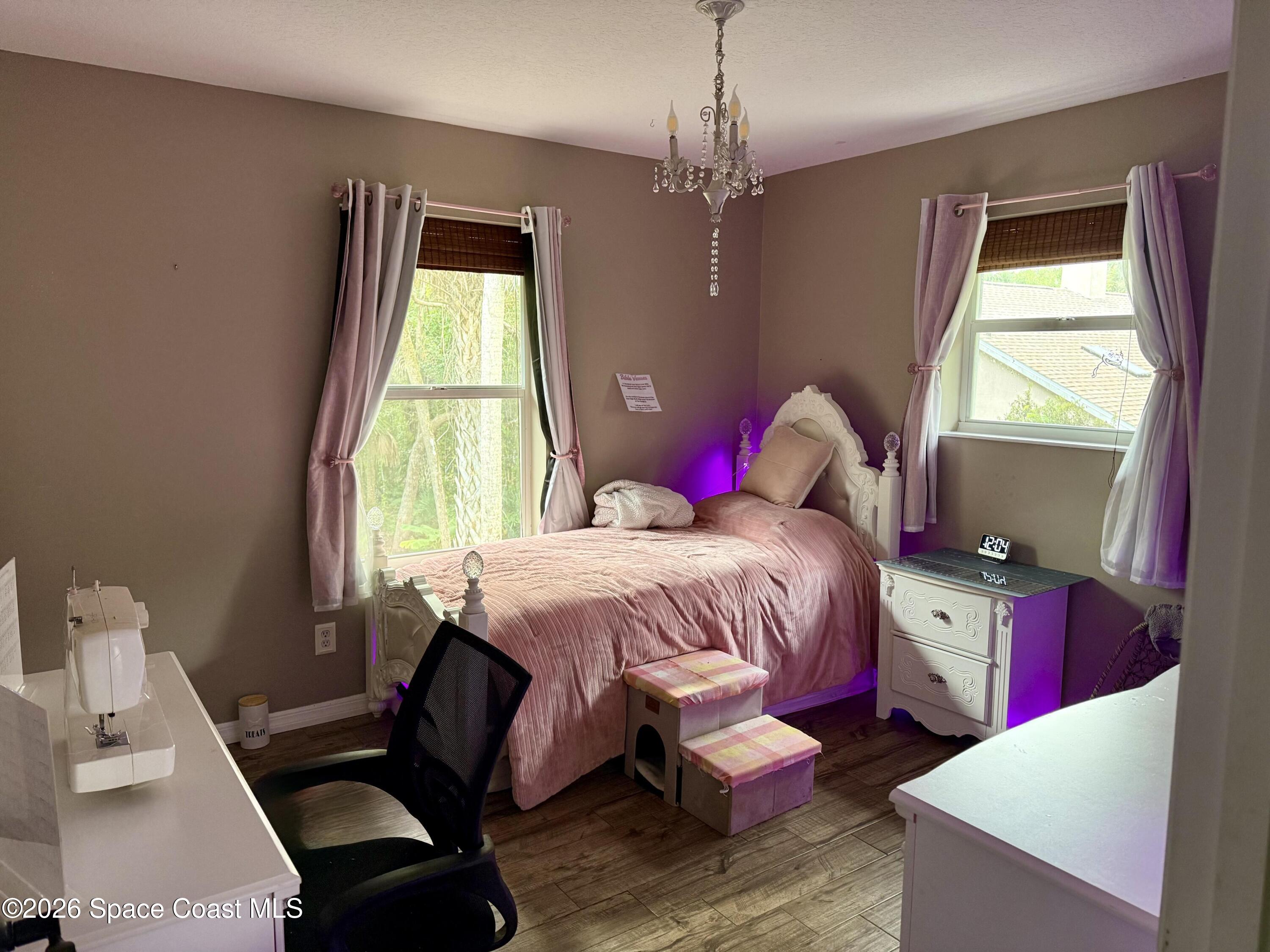 111 Seagrape Road Melbourne Beach, FL 32951 - Photo 18 of 19 a spacious bedroom with a bed and a chandelier