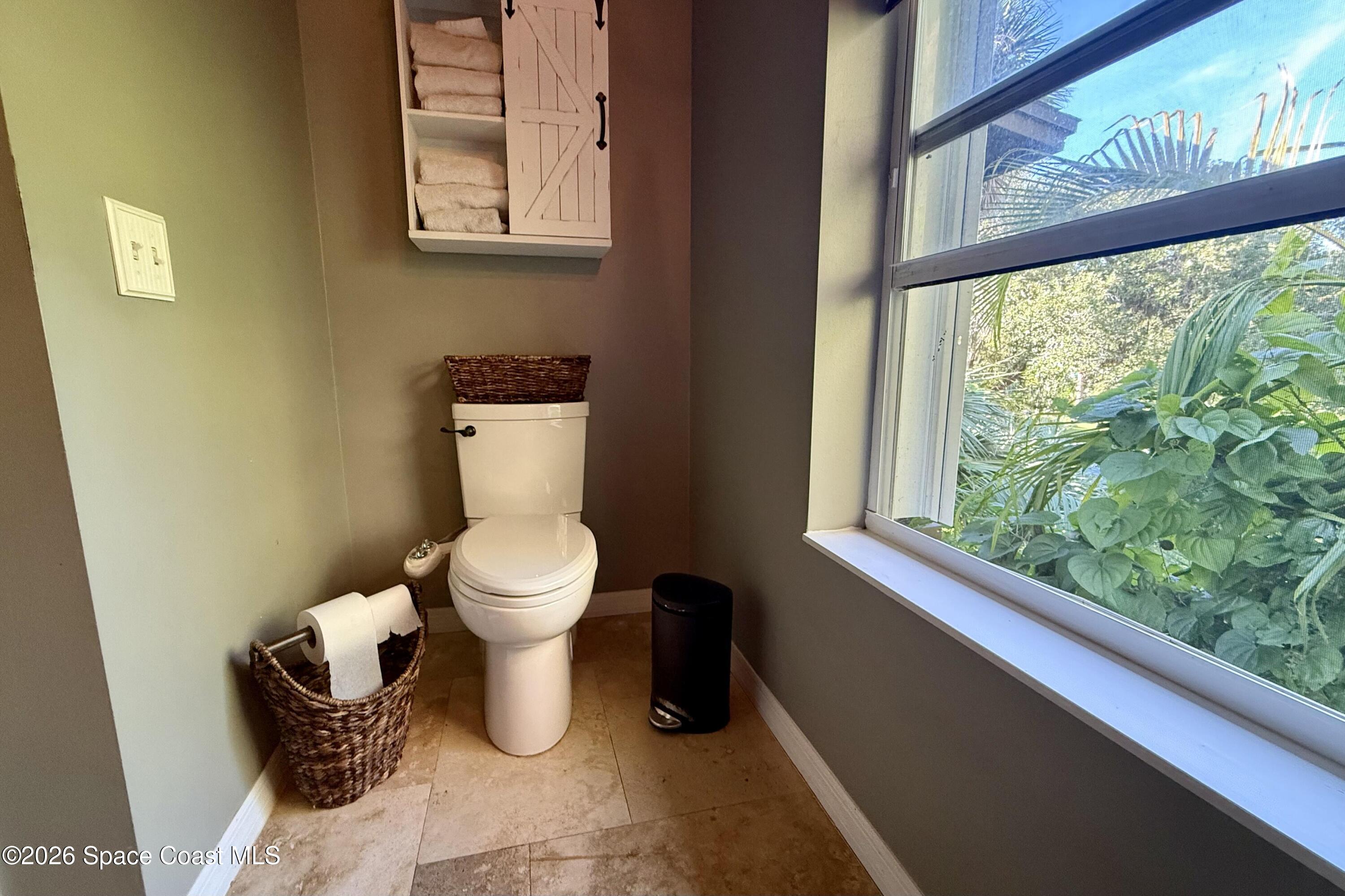 111 Seagrape Road Melbourne Beach, FL 32951 - Photo 4 of 19 a bathroom with a toilet and a window