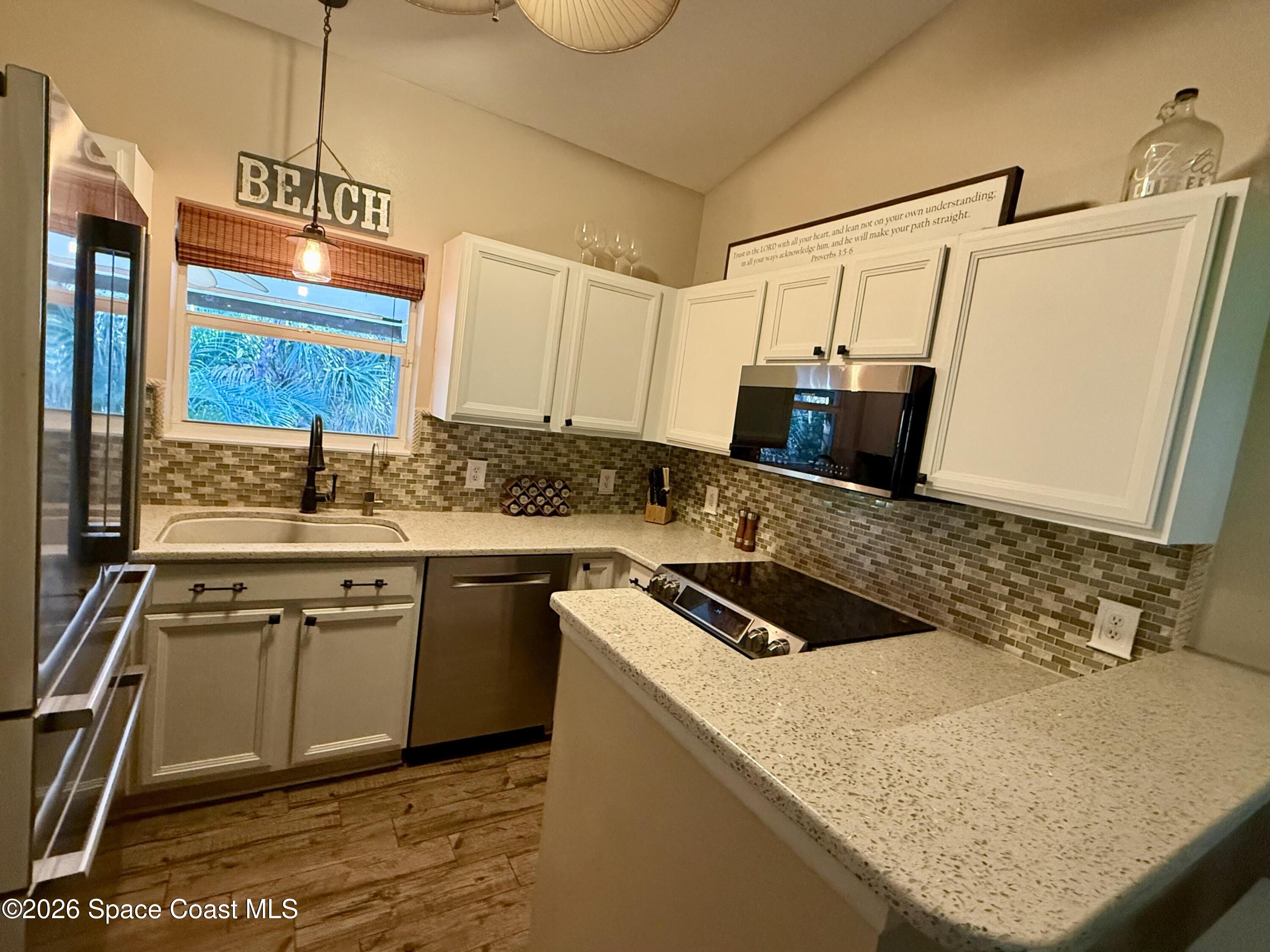 111 Seagrape Road Melbourne Beach, FL 32951 - Photo 6 of 19 a kitchen with kitchen island granite countertop a sink and stove