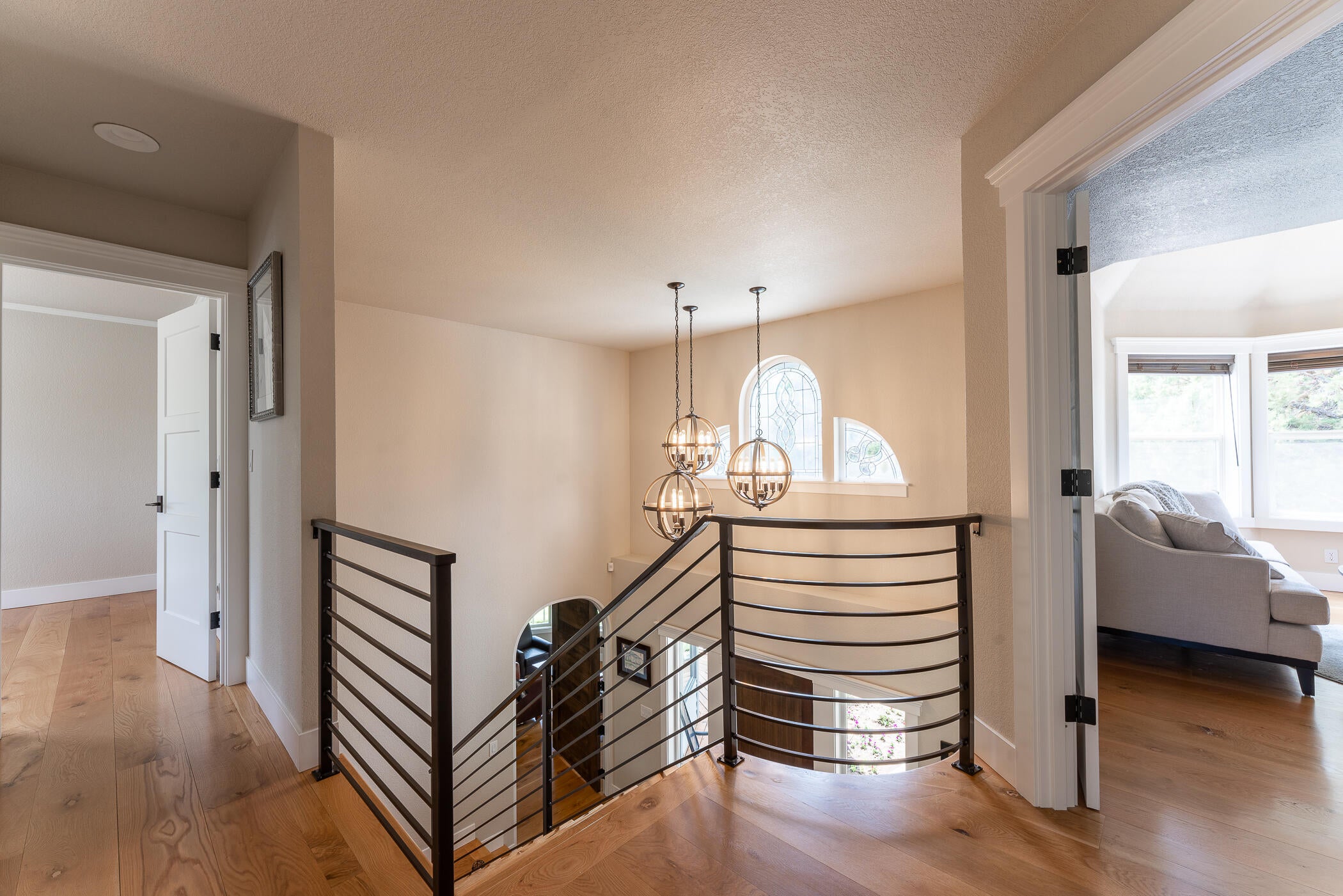 64300 Crosswinds Road Bend, OR 97703 - Photo 23 of 61 Landing at the top of the stairs. Beautiful wide plank hardwoods throughout the home, including the grand stairway. Primary suite is located to the left at the top of the stairs.