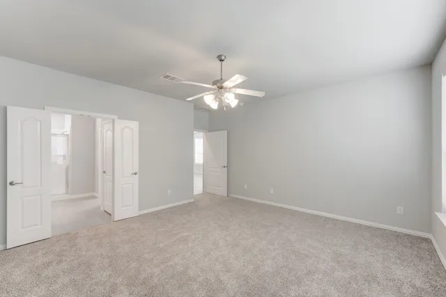a view of an empty room with a chandelier fan