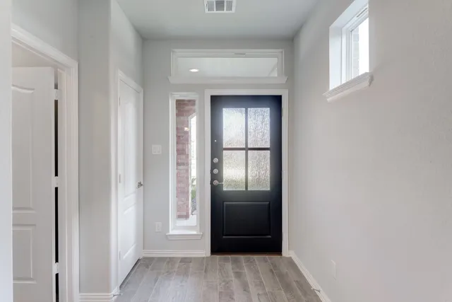 a view of a hallway with wooden floor and closet