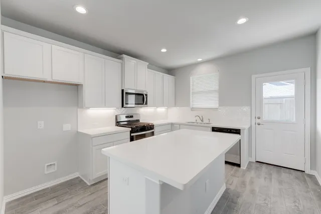 a kitchen with white cabinets and white appliances