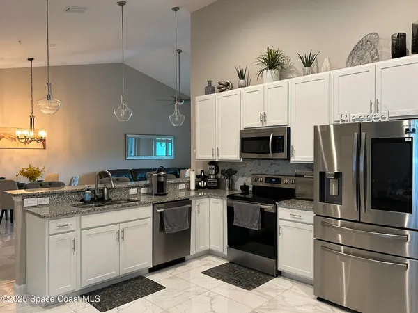 a kitchen with a sink stainless steel appliances and white cabinets