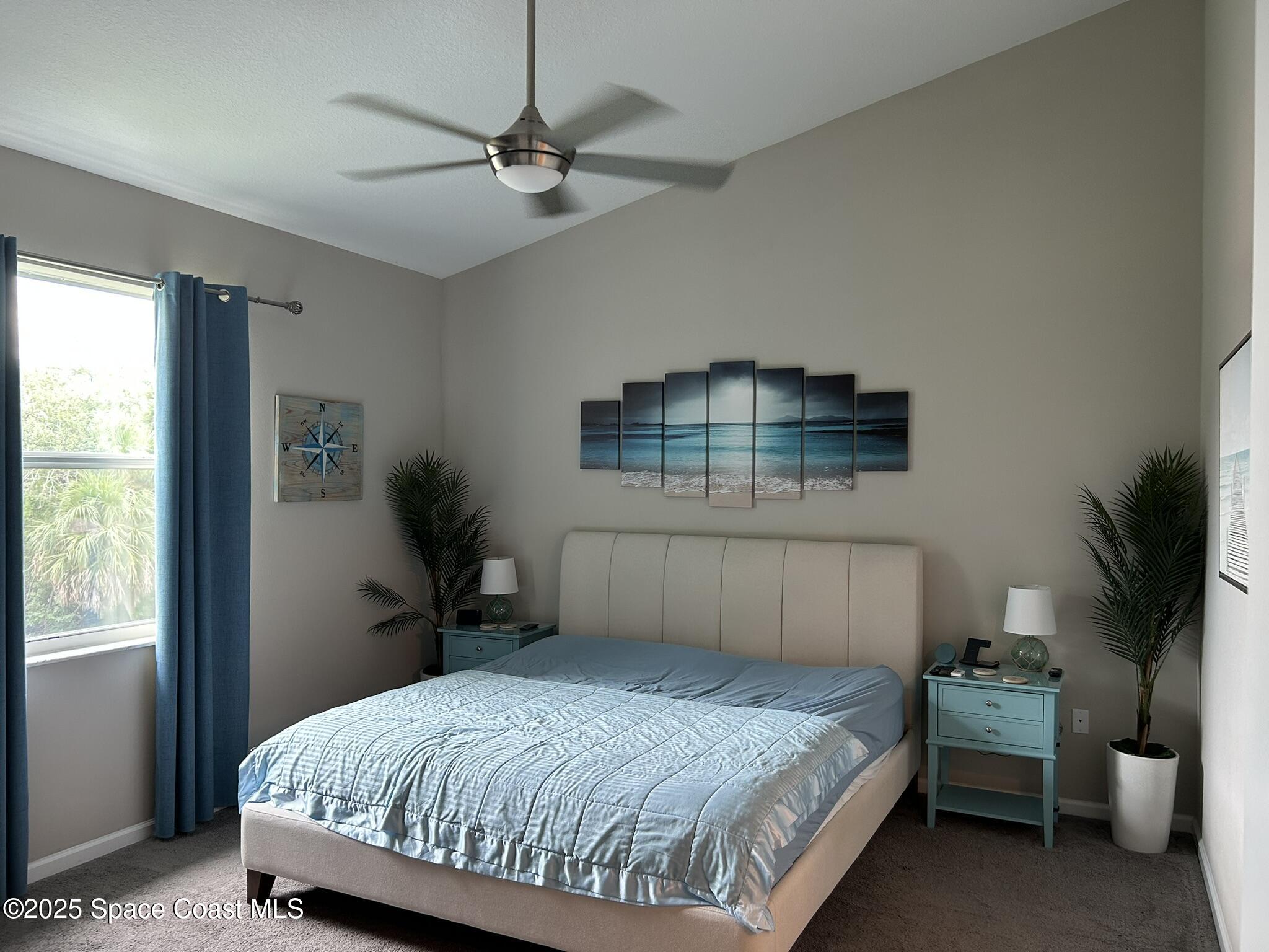 3931 Playa Del Sol Drive, Unit 203 Rockledge, FL 32955 - Photo 25 of 36 a bedroom with a bed and a chandelier