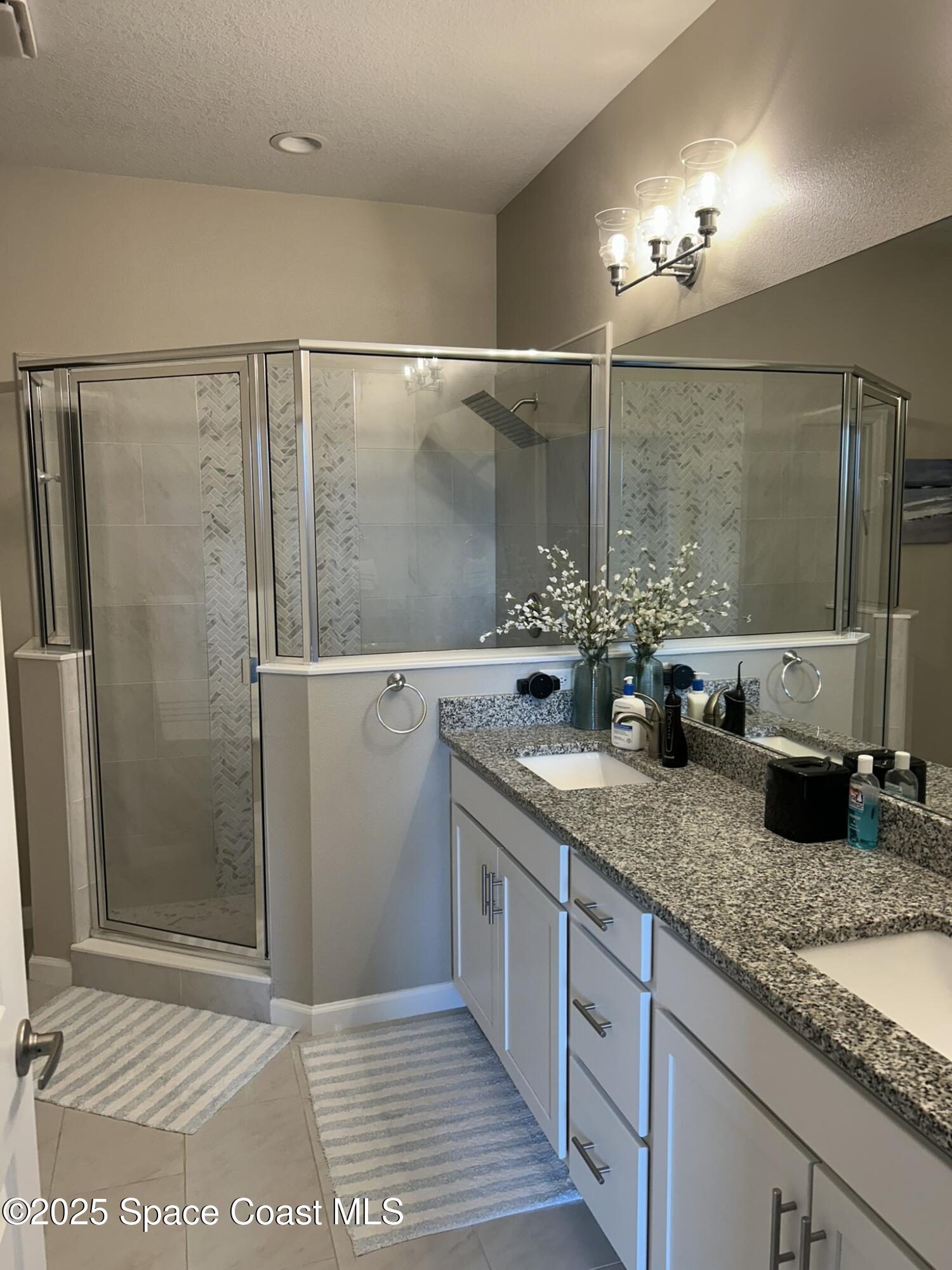 3931 Playa Del Sol Drive, Unit 203 Rockledge, FL 32955 - Photo 34 of 36 a bathroom with double vanity and a shower