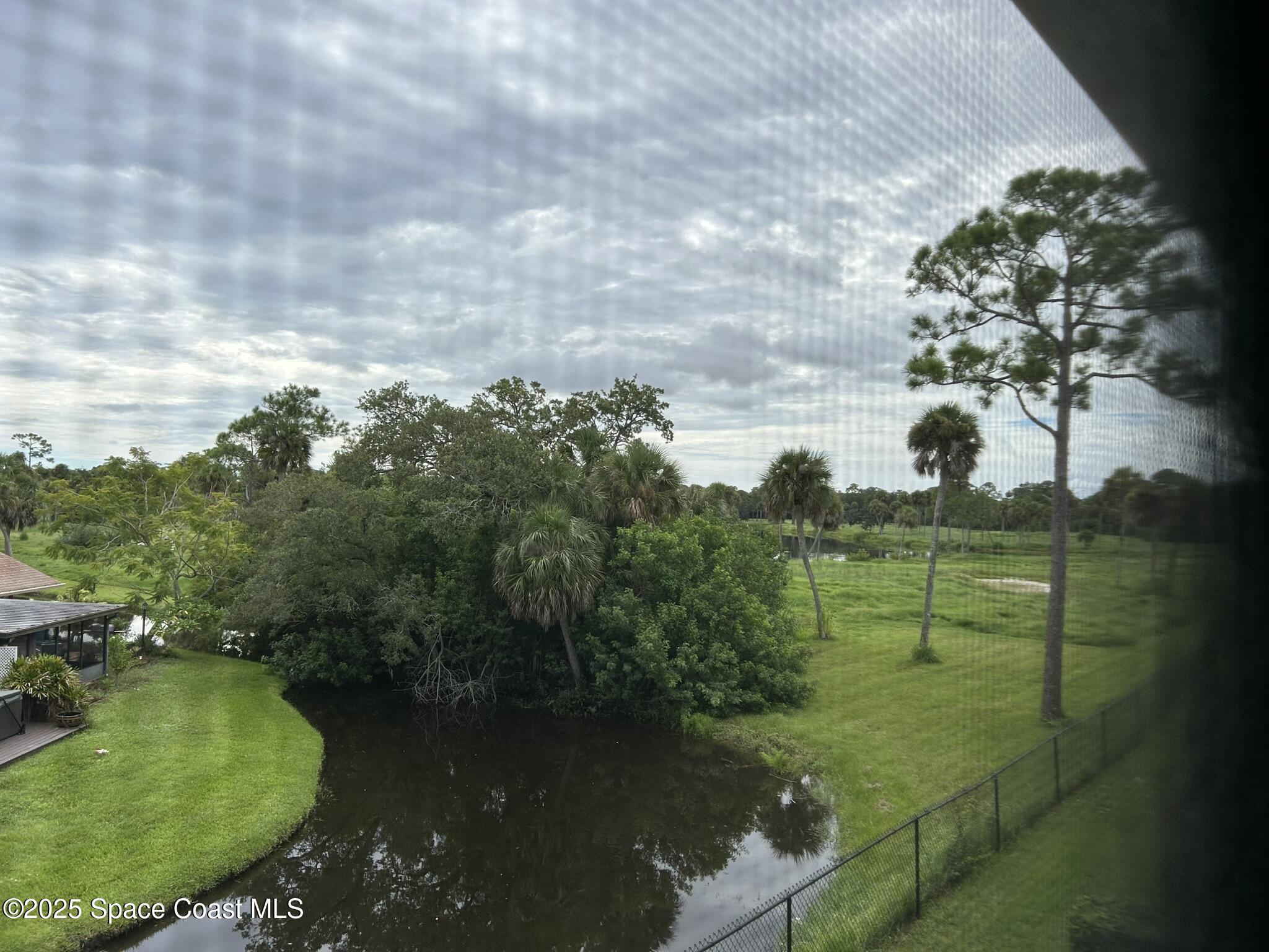 3931 Playa Del Sol Drive, Unit 203 Rockledge, FL 32955 - Photo 36 of 36 a view of a lake with a yard