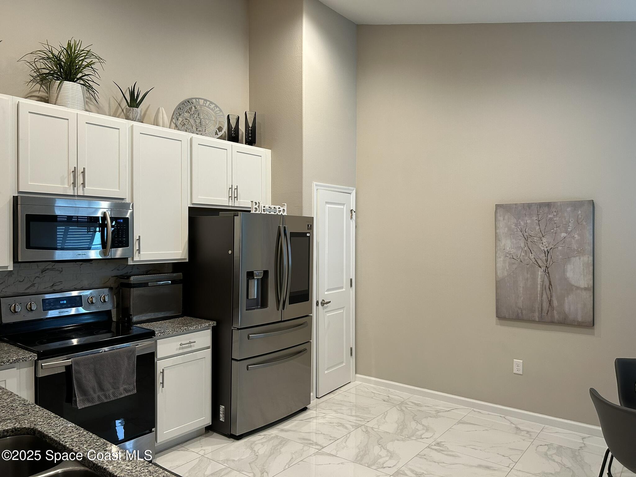 3931 Playa Del Sol Drive, Unit 203 Rockledge, FL 32955 - Photo 4 of 36 a kitchen with stainless steel appliances kitchen island granite countertop a refrigerator and a stove top oven