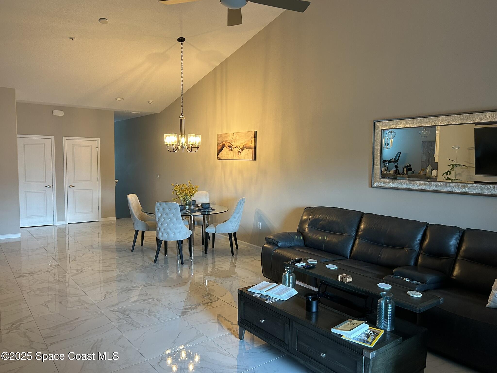 3931 Playa Del Sol Drive, Unit 203 Rockledge, FL 32955 - Photo 8 of 36 a living room with furniture a dining table and a piano with wooden floor
