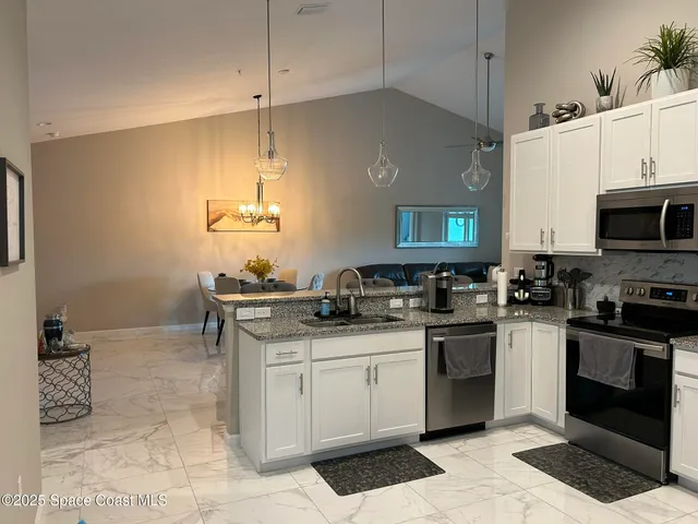 a kitchen with stainless steel appliances granite countertop a sink stove and cabinets