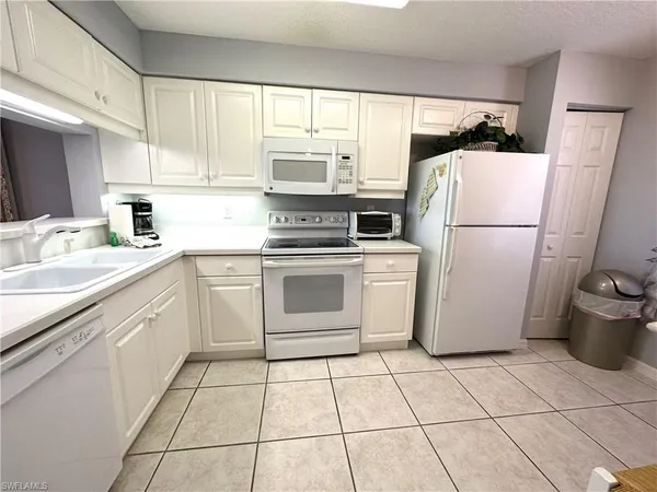 a utility room with cabinets washer and dryer