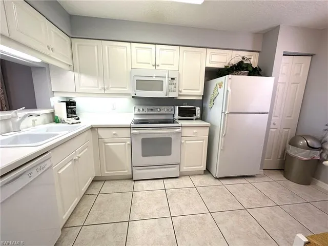 a utility room with cabinets washer and dryer