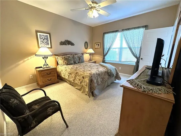 a bedroom with bed a flat tv screen and a dresser with the dresser