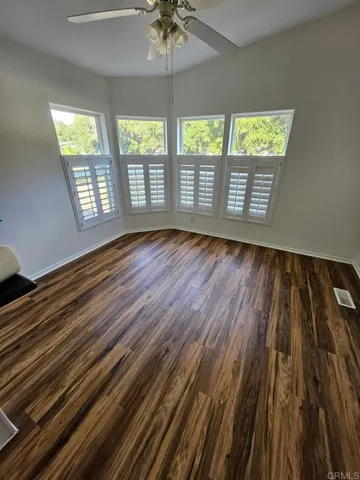 wooden floor in an empty room with a window