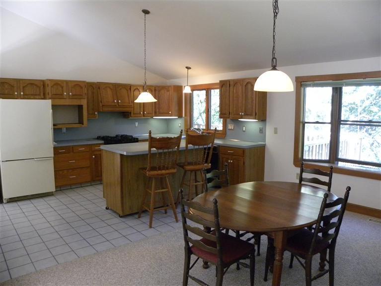 9 Josephs Road Truro, MA 02666 - Photo 3 of 14 a kitchen with a dining table chairs and white cabinets